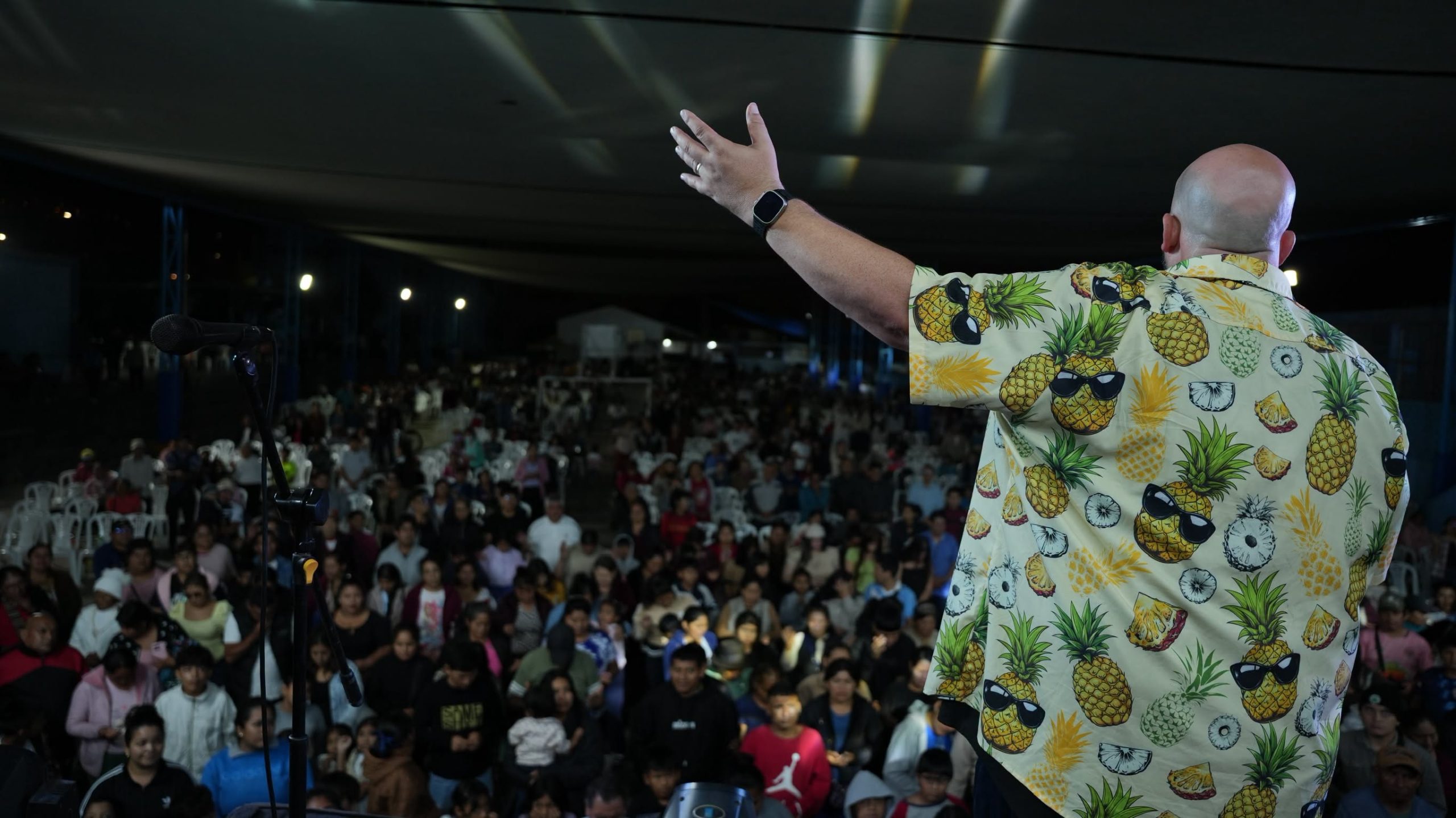 Ben Hughes raising his hand while ministering to a crowd in Peru in October 2026